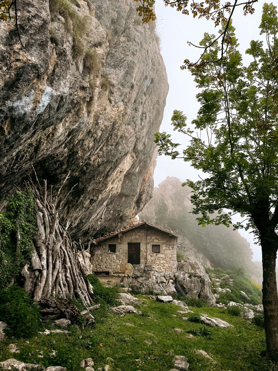 Refugio de piedra bajo un gran resalte de roca