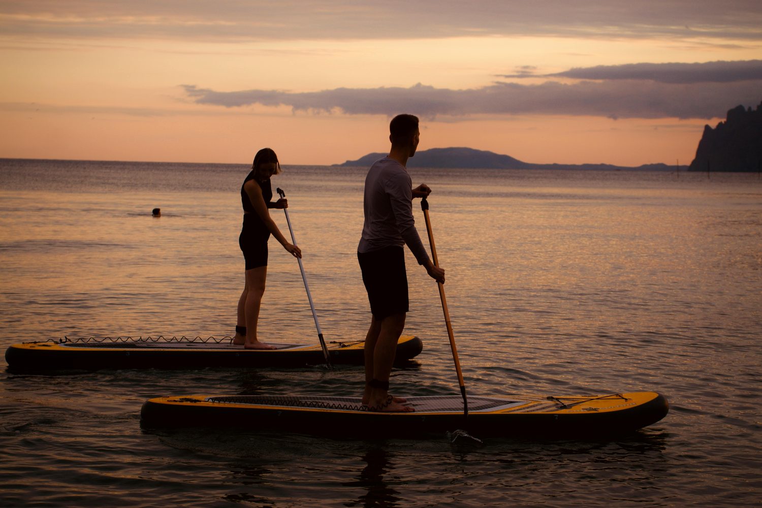 Pareja en paddle surf al atardecer