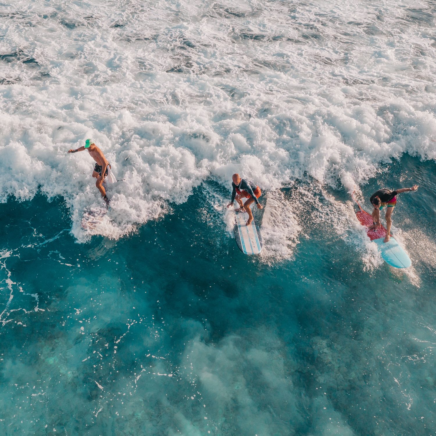 Clase de surf con tres personas en olas pequeñas
