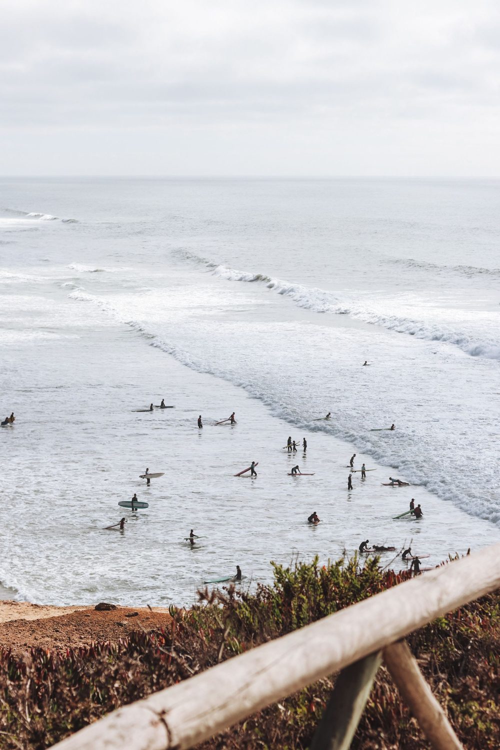 Decenas de surfistas en el pico esperando olas